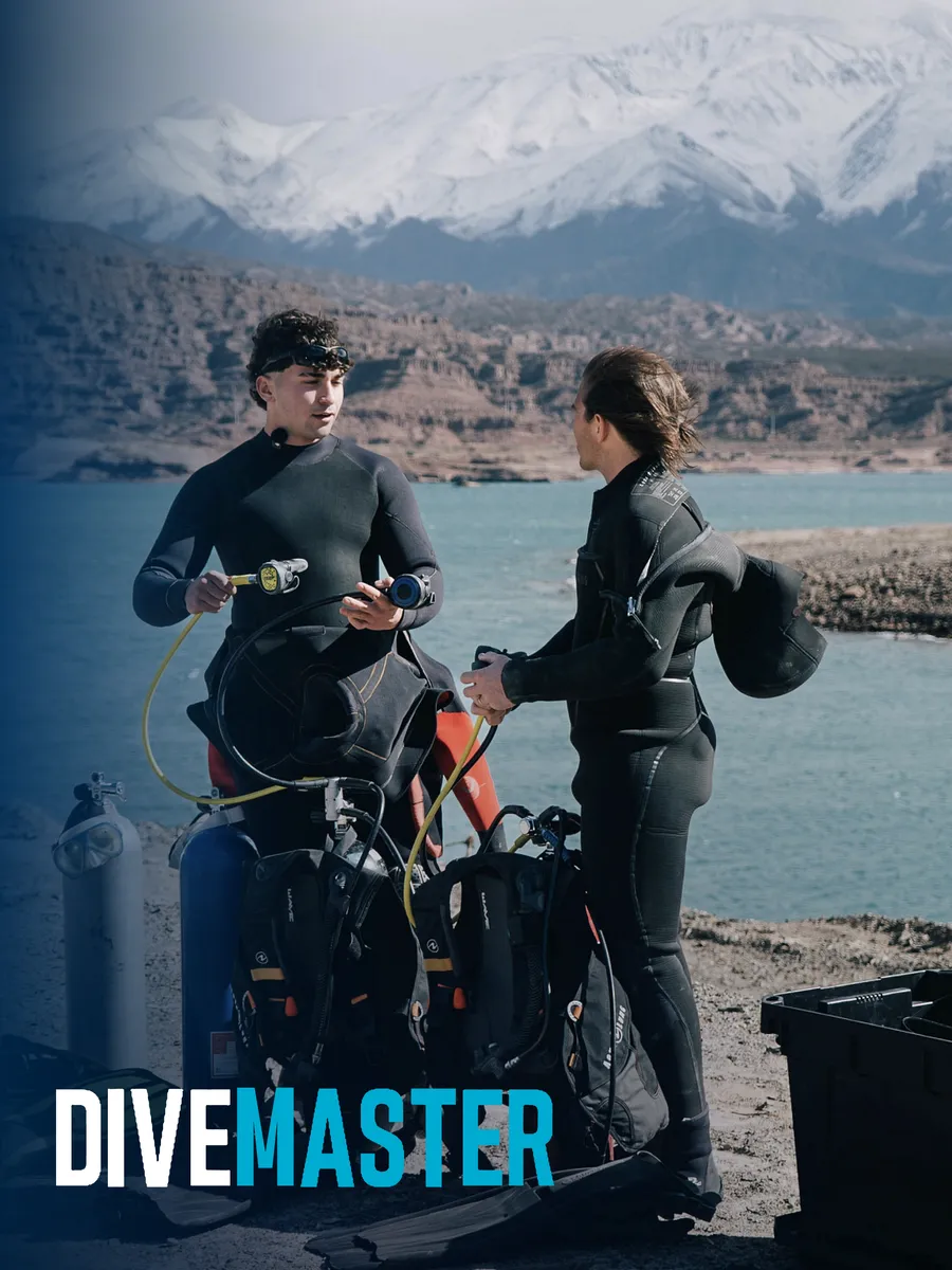 Dos buzos revisando reguladores a orillas del dique Potrerillos